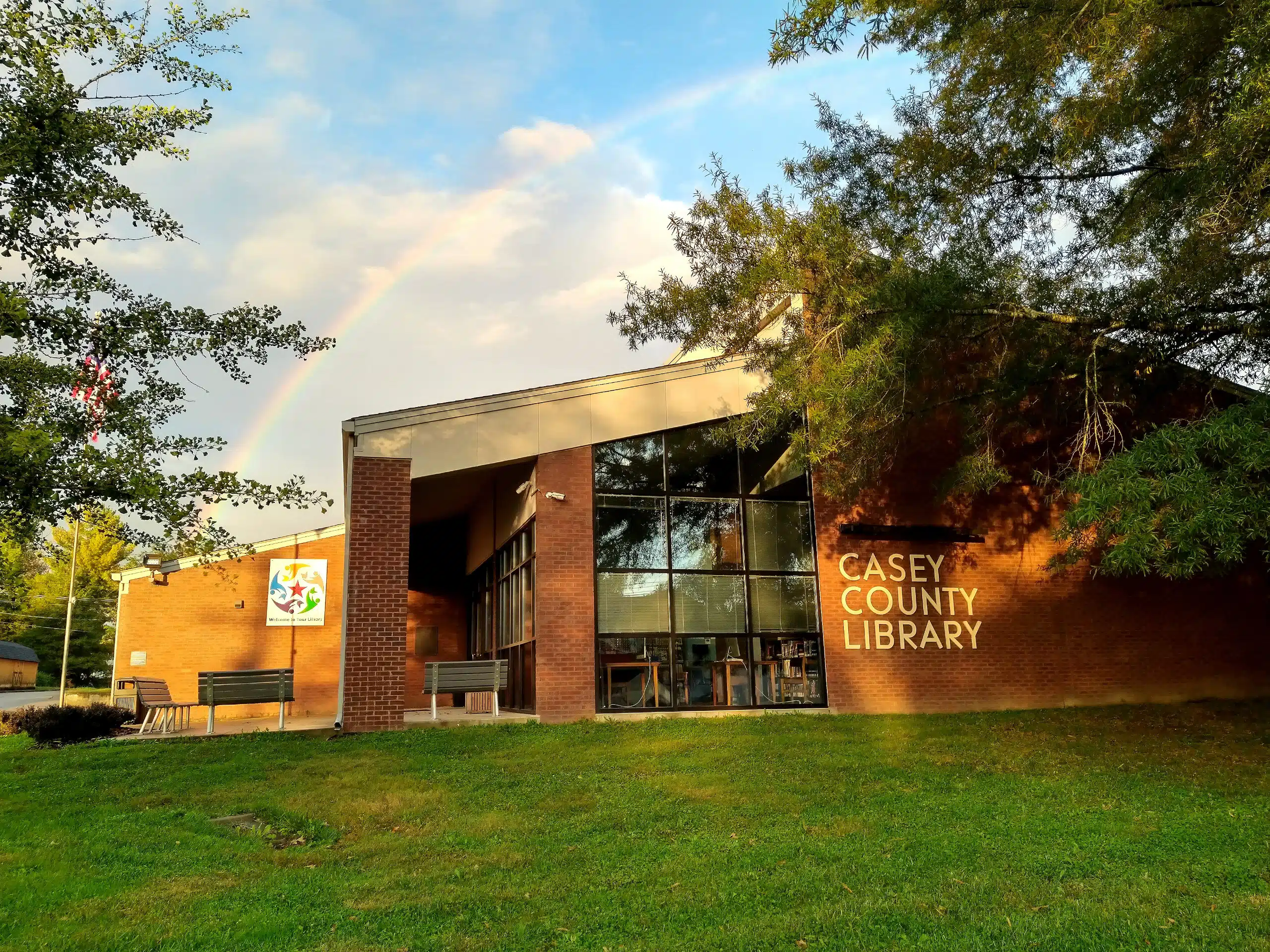 Exterior view of Casey County Public Library, with a rainbow in the sky